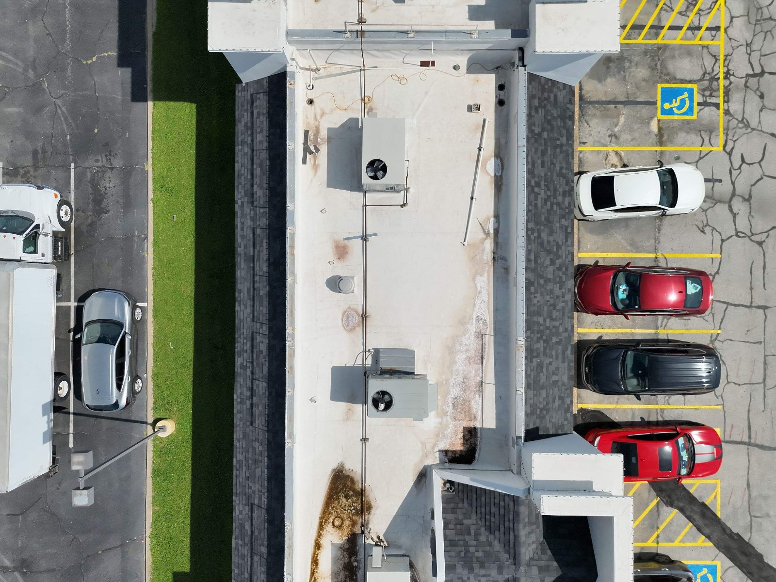 Daytime drone photo of a commercial roof with areas marked for follow-up
