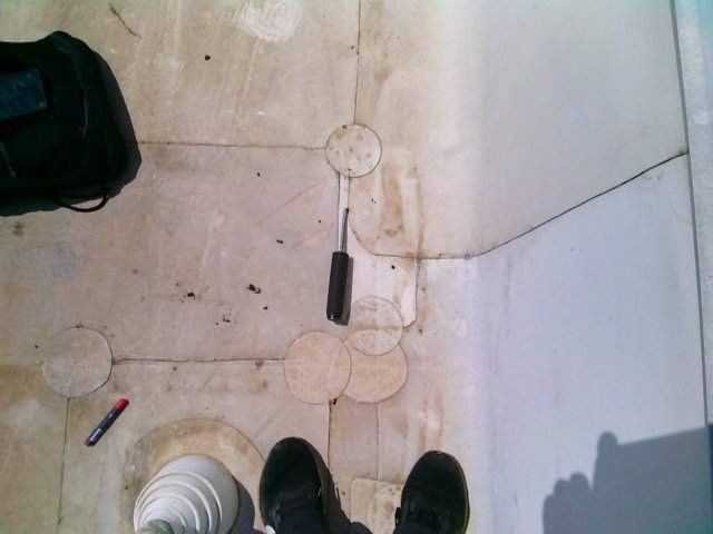 Patched seams on a white TPO roof being checked with a moisture probe